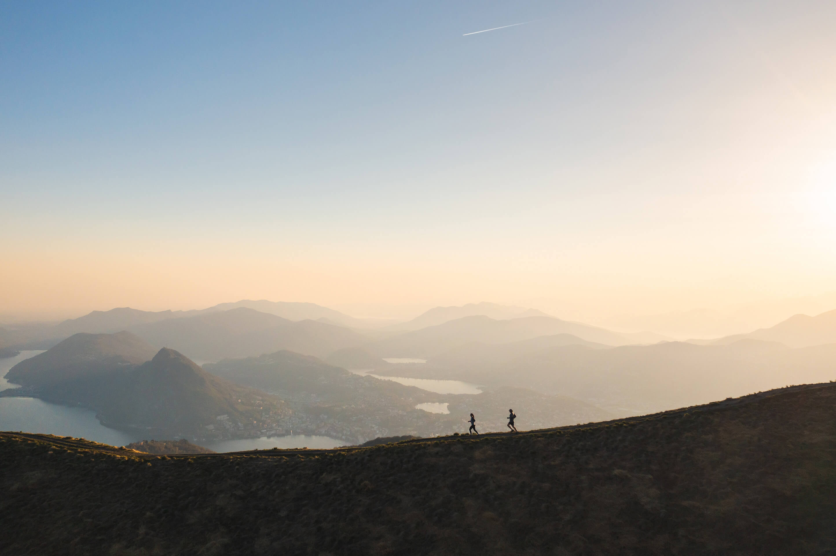 Two trail runners scaling a mountain