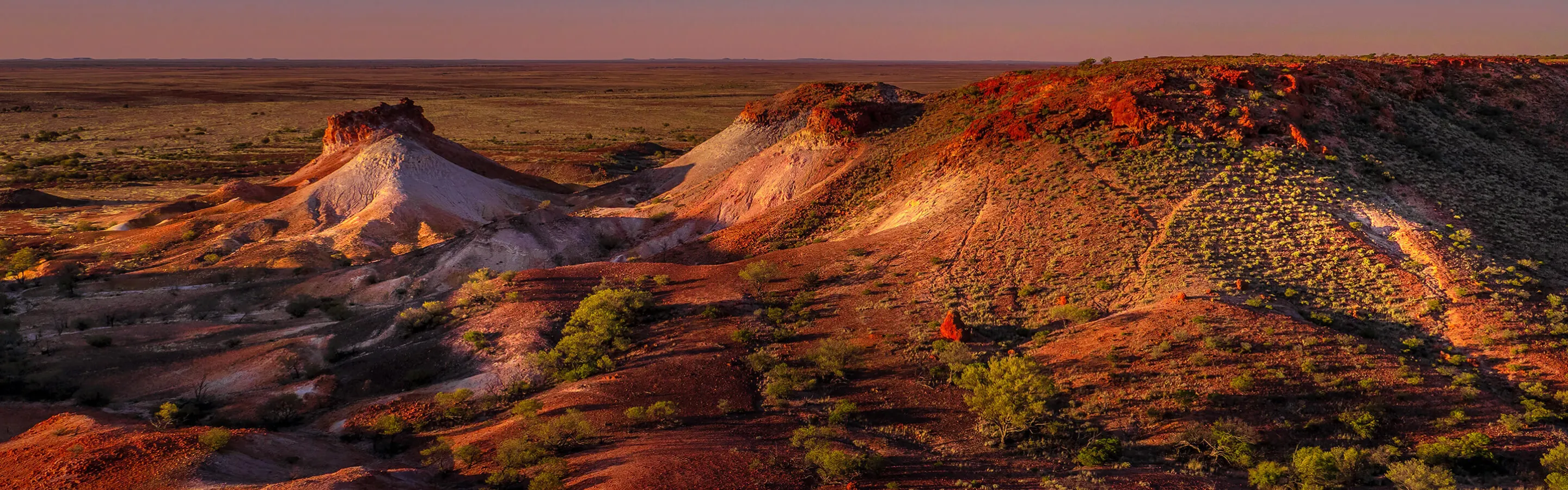 View of hilly desert landscape at sunset