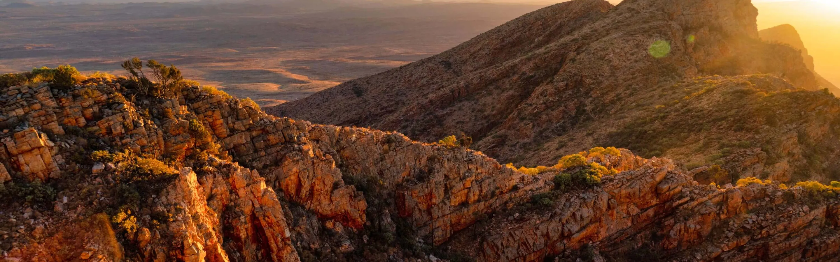 Mountain range view with clear blue sky and sun in the background