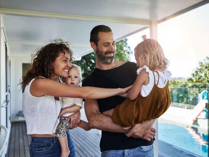 Mum and dad with two young daughters on their deck at home