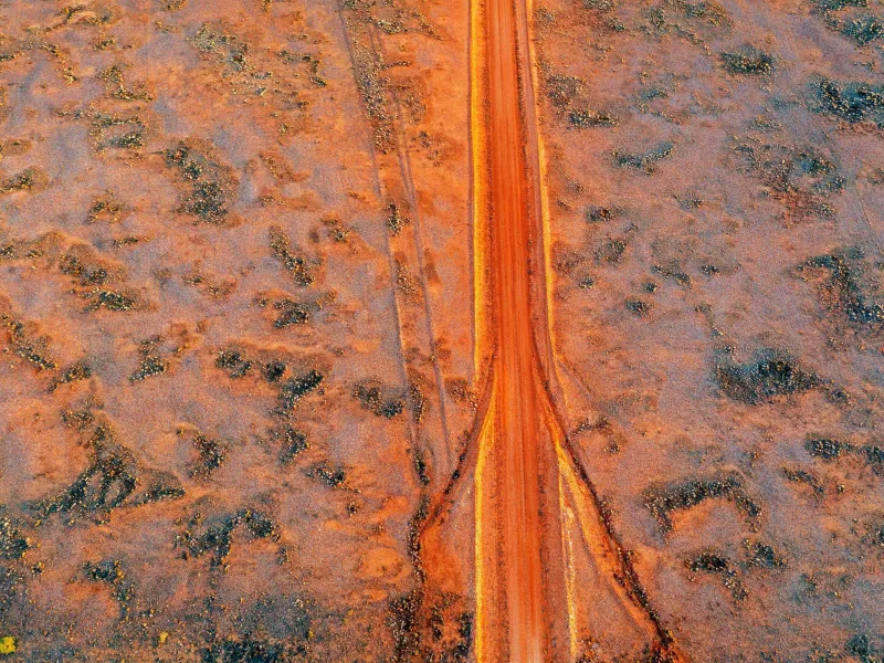 Red dirt road through desert landscape
