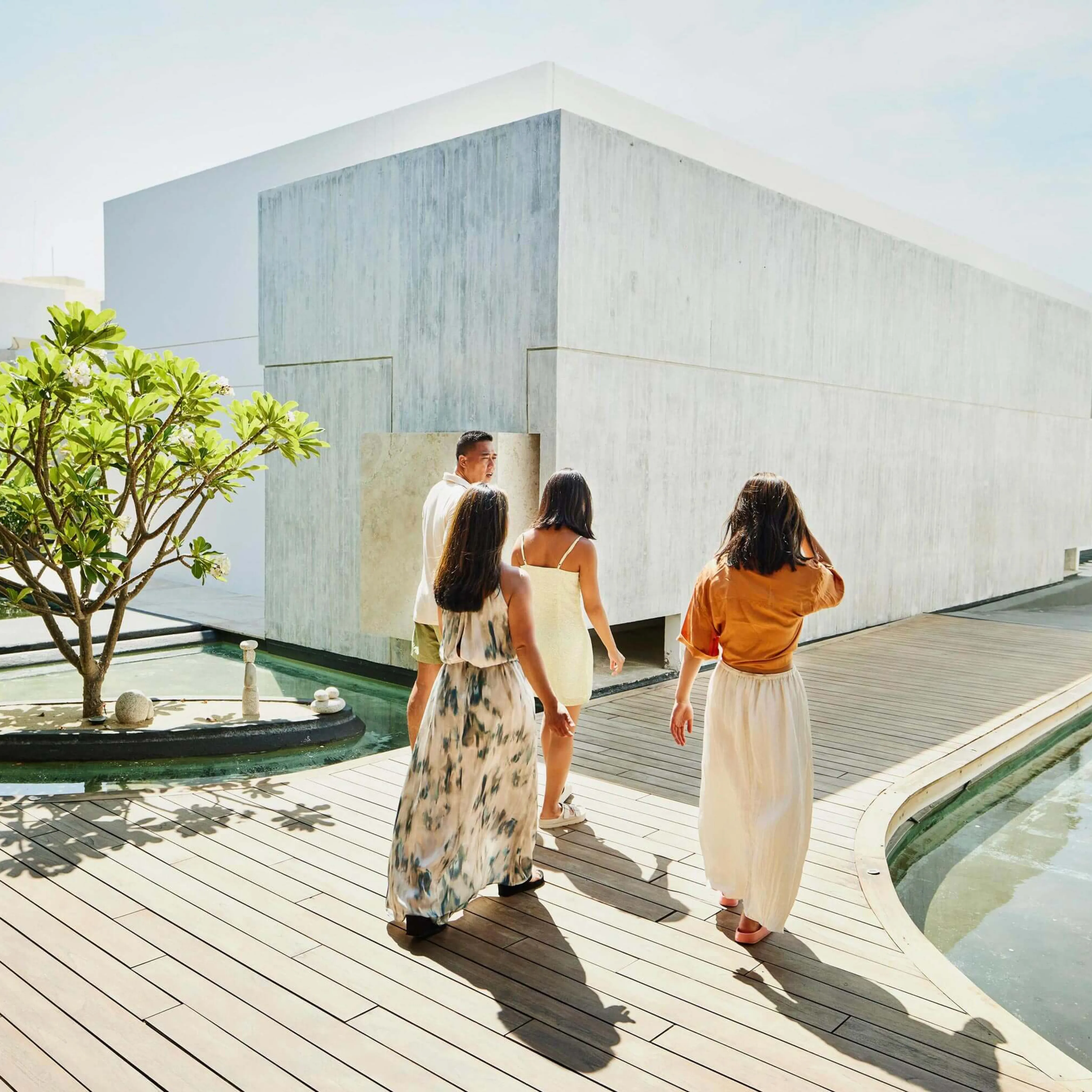 Family of four walking through hotel next to pool